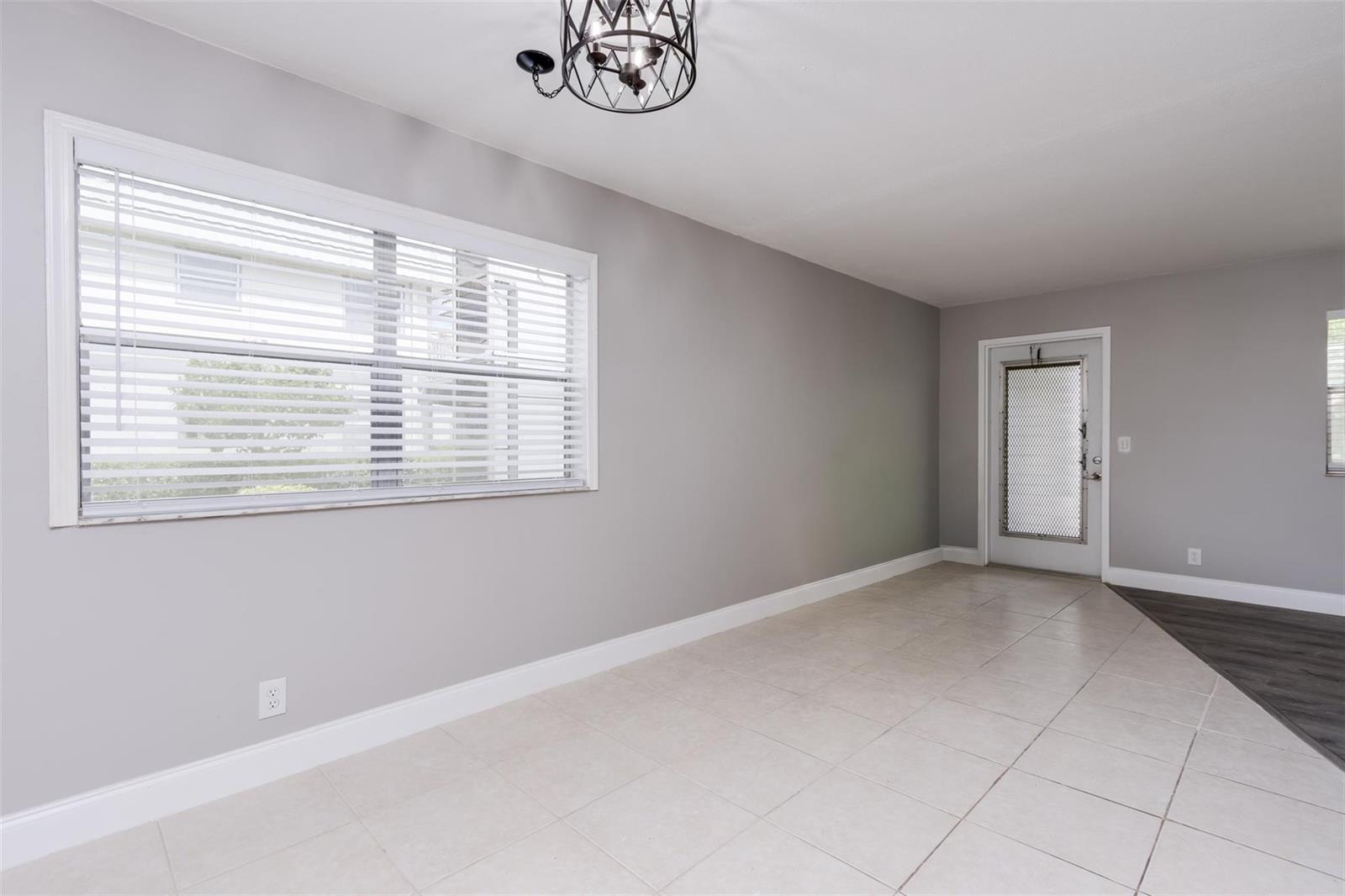 A room with light gray walls, tile flooring, a large window with blinds, and a door — 346 Monaco H # 346, Delray Beach FL 33446, DELRAY BEACH, FL