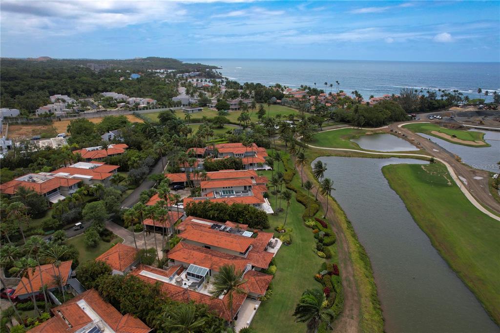 An aerial view shows a coastal residential complex with red-tiled roofs near a golf course — 5 THE GREENS VILLAS AT DORADO BEACH, DORADO, PR