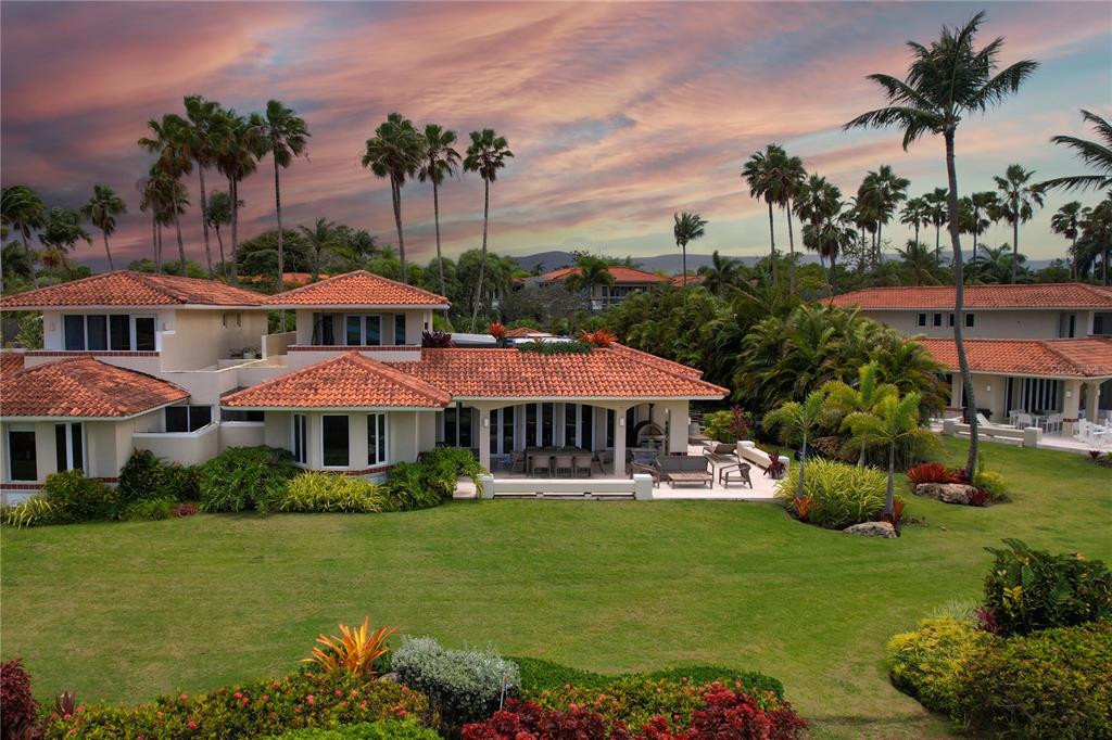 A large, two-story house with a red tile roof overlooks a spacious, landscaped green lawn — 5 THE GREENS VILLAS AT DORADO BEACH, DORADO, PR