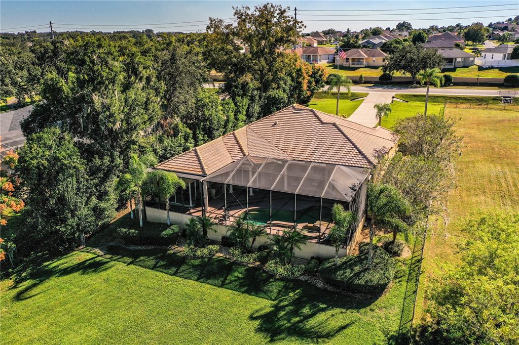 An aerial view of a house with a screened-in pool and a large grassy backyard — 2918 CLUBHOUSE ROAD, LAKELAND, FL