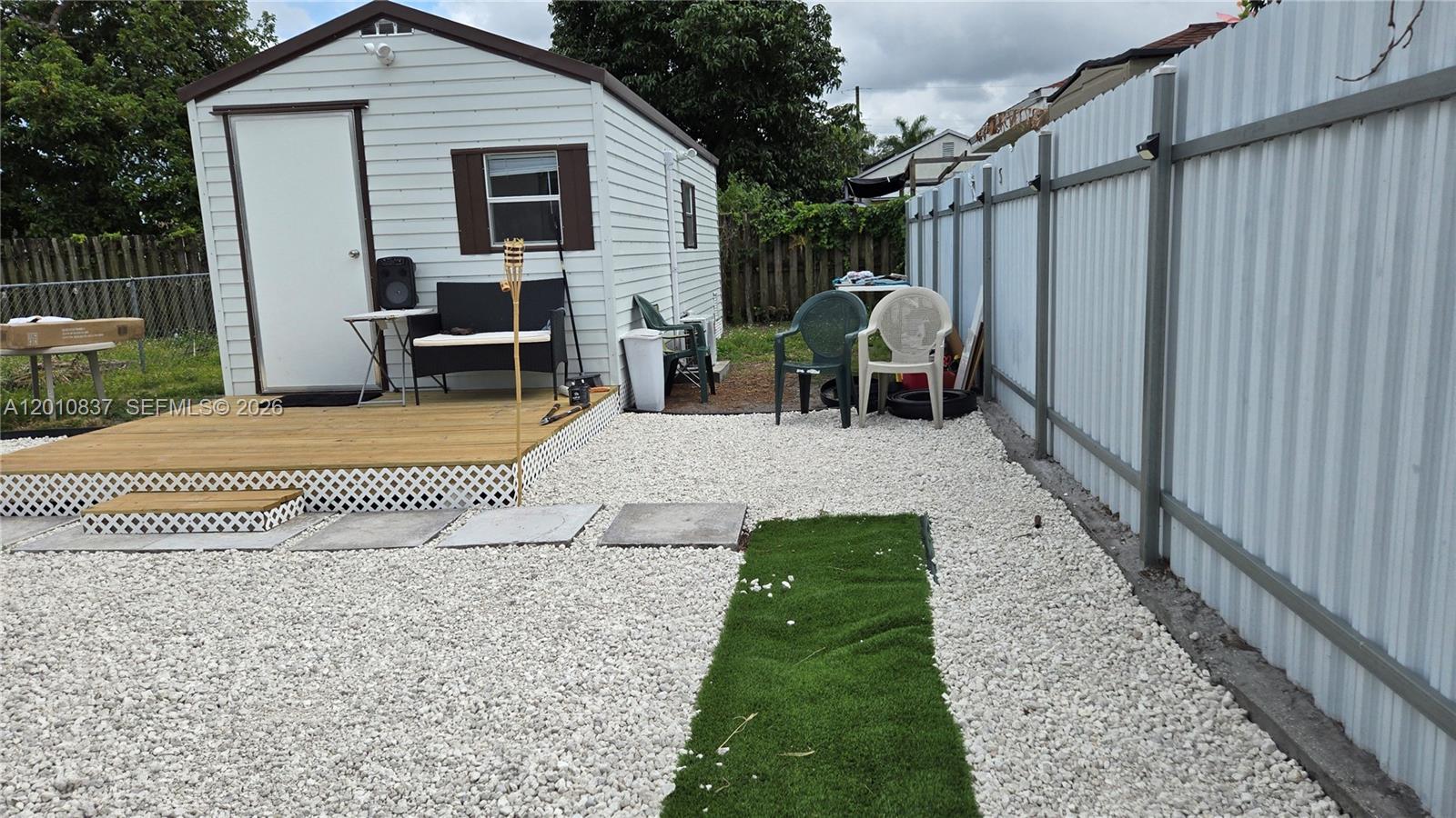 A small shed with a wooden deck sits in a yard covered with white gravel — 2440 NW 99th St # A, Miami FL 33147, MIAMI, FL