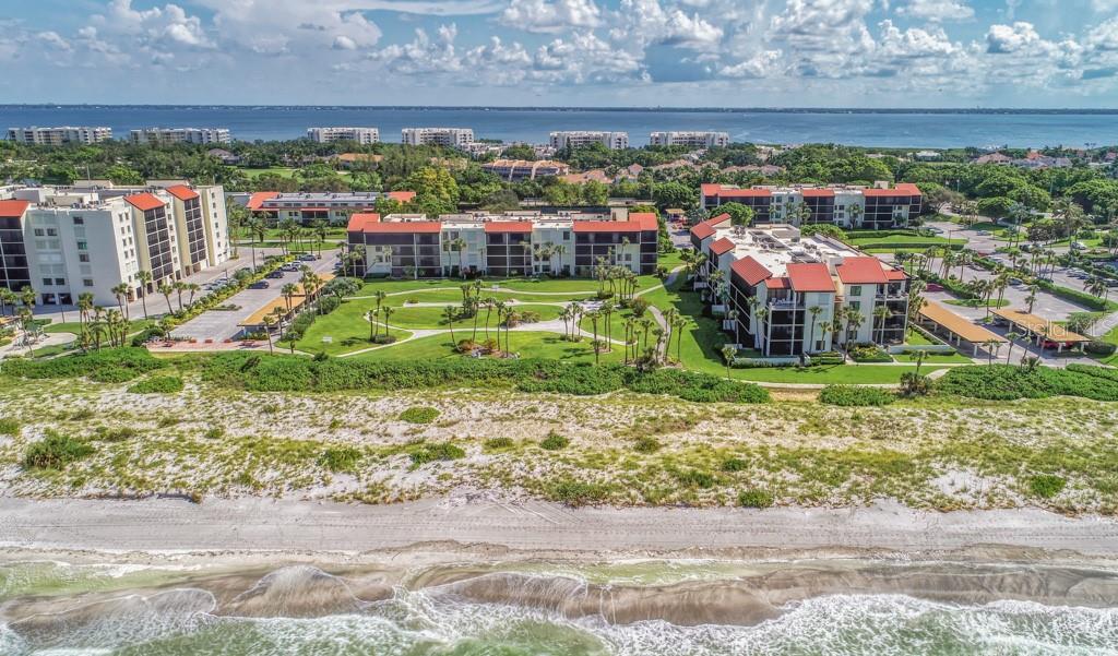 An aerial view of beachfront condominium buildings with a central lawn and parking areas — 1975 GULF OF MEXICO DRIVE UNIT G4-401, LONGBOAT KEY, FL