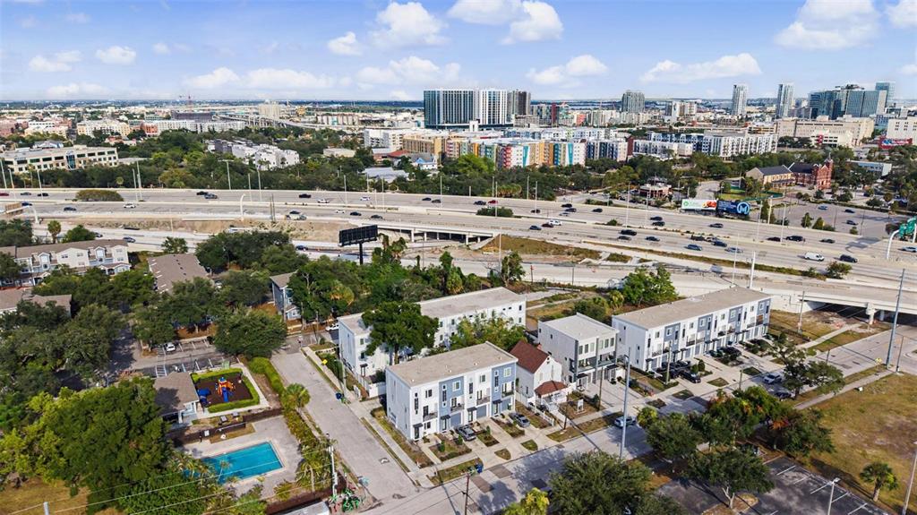 An aerial view shows a residential complex with a pool, playground, and nearby highway overpass — 1527 N MORGAN STREET, TAMPA, FL