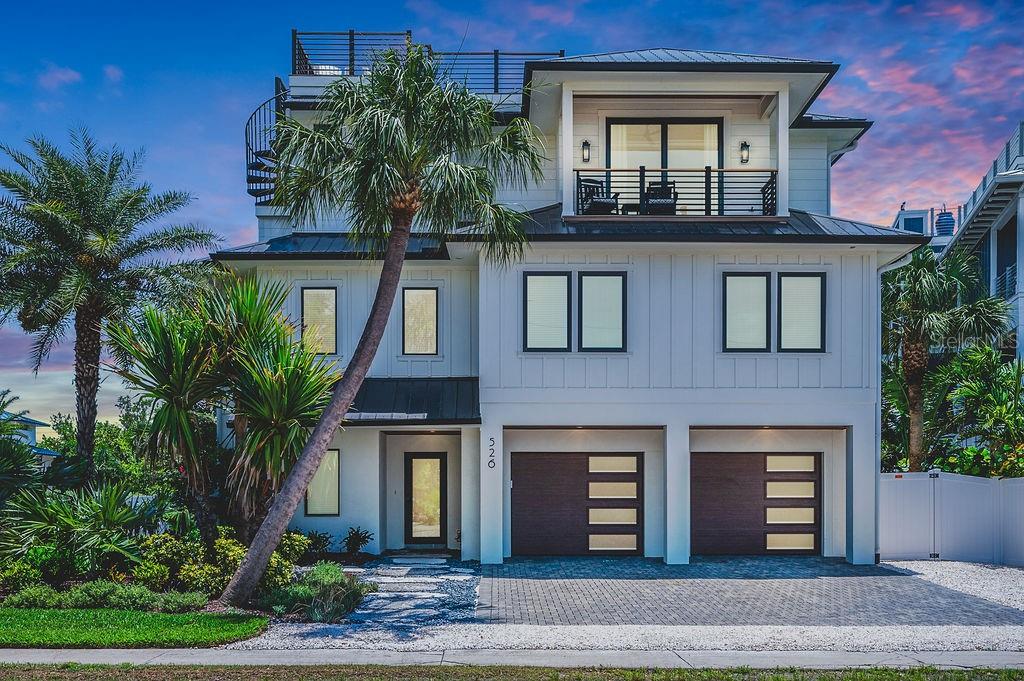 A three-story white house with a two-car garage, a balcony, and a rooftop deck — 526 SEAGULL WAY, ANNA MARIA, FL