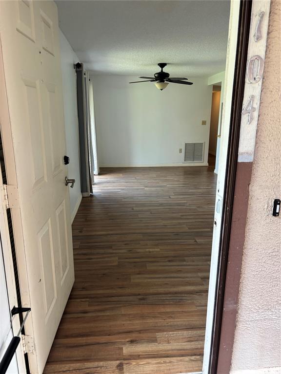An open doorway reveals a room with wood-look flooring and a ceiling fan — 5026 WATER OAK DRIVE UNIT 104, BRADENTON, FL