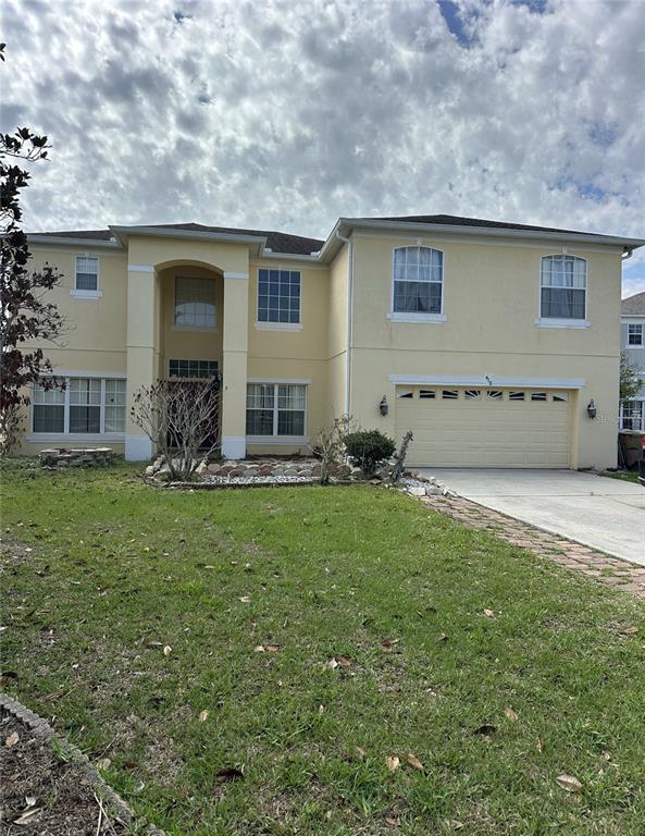 A two-story, light yellow house with a two-car garage and a front yard — 418 MARLBERRY LEAF COURT, KISSIMMEE, FL