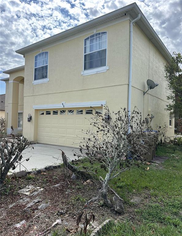 A two-story house with a beige stucco exterior and a two-car garage — 418 MARLBERRY LEAF COURT, KISSIMMEE, FL