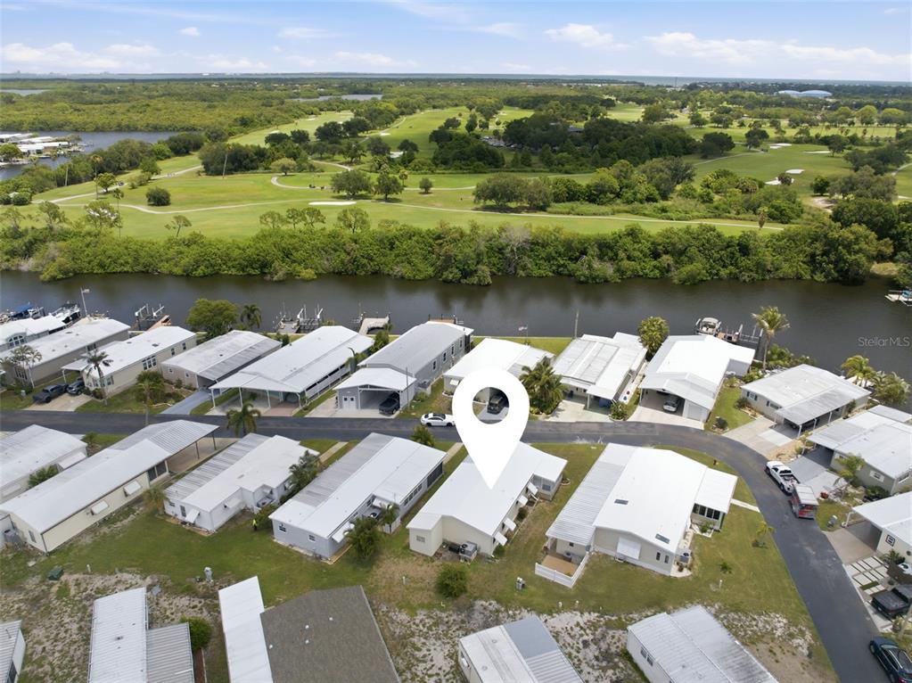 A single-story manufactured home with light yellow siding, a carport, and a front lawn — 6826 MOUNT ORANGE DRIVE NE UNIT 383, ST PETERSBURG, FL