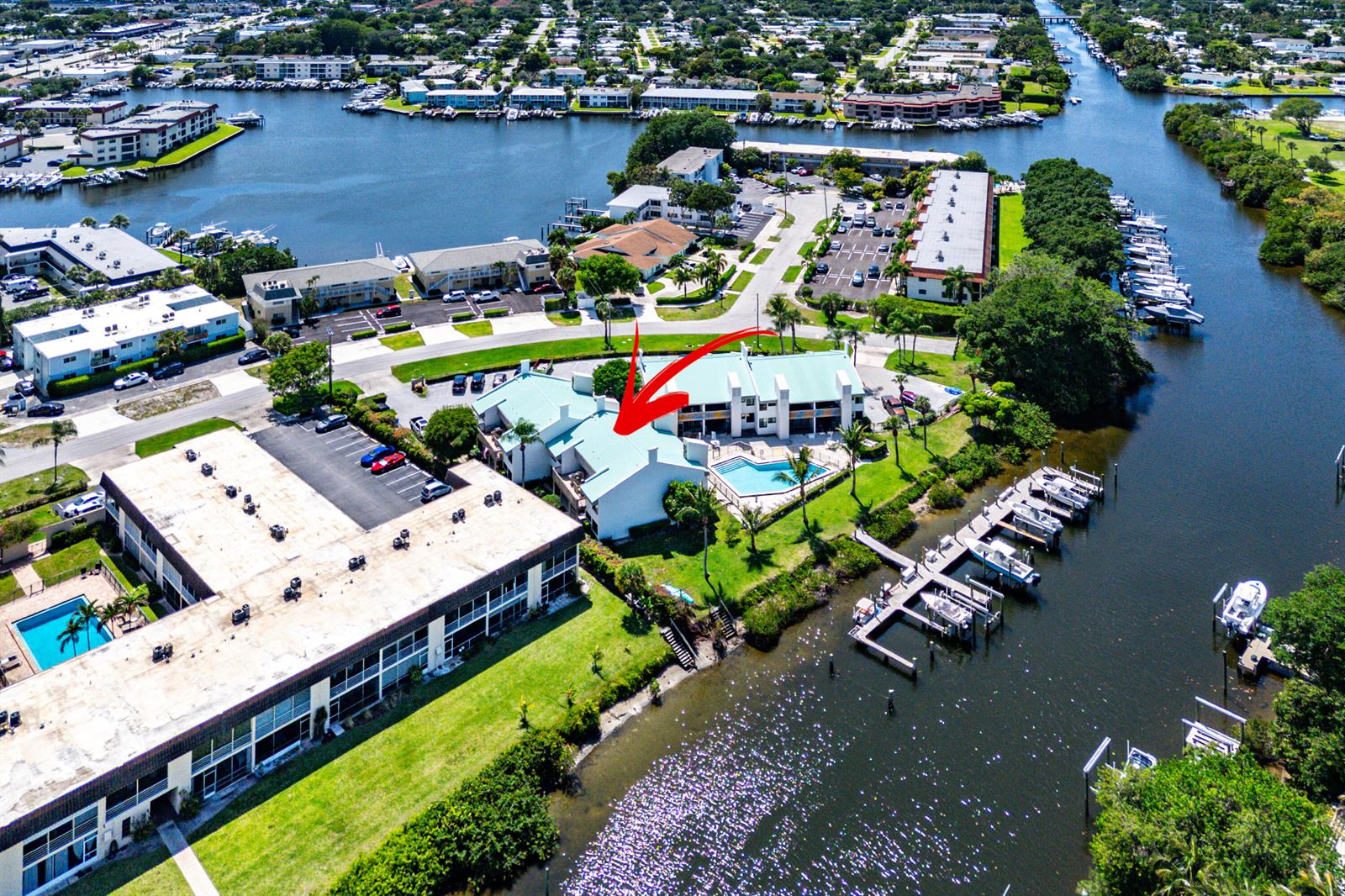 An aerial view shows a waterfront condominium complex with a swimming pool and boat slips — 412 Southwind Drive # B2, North Palm Beach FL 33408, NORTH PALM BEACH, FL