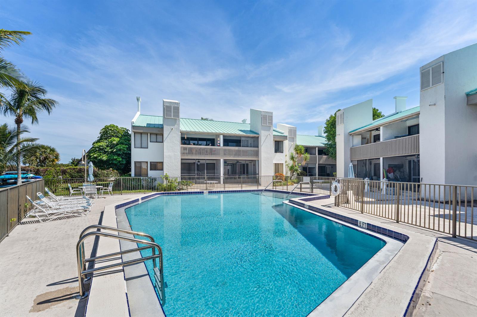 A swimming pool sits in front of a multi-story apartment building with balconies — 412 Southwind Drive # B2, North Palm Beach FL 33408, NORTH PALM BEACH, FL