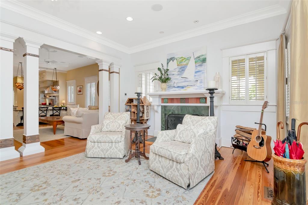 A living room features two patterned armchairs, a fireplace, and an adjacent open-concept kitchen — 713 S DELAWARE AVENUE, TAMPA, FL