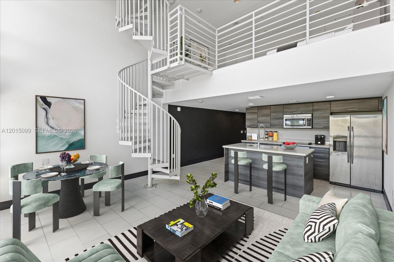 A modern living area features a spiral staircase, kitchen island, and a lofted bedroom level — 421 Meridian Ave # 19, Miami Beach FL 33139, MIAMI BEACH, FL