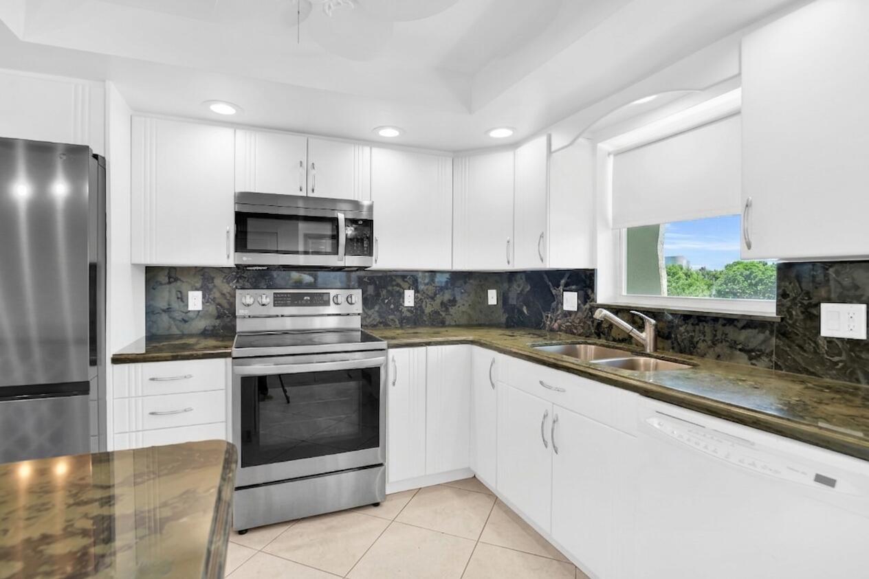 A kitchen with white cabinets, stainless steel appliances, and dark green stone countertops — 1850 S Ocean Boulevard # 304, Pompano Beach FL 33062, POMPANO BEACH, FL