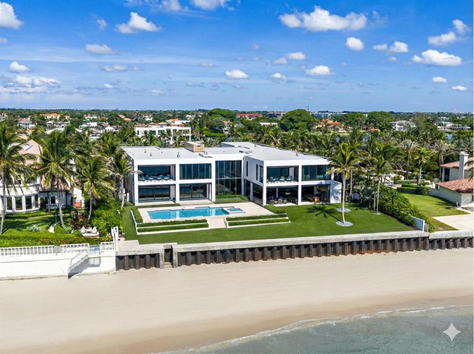 An aerial view of a modern two-story beachfront mansion with a pool and grassy lawn — 1260 S Ocean Boulevard, Manalapan FL 33462, MANALAPAN, FL