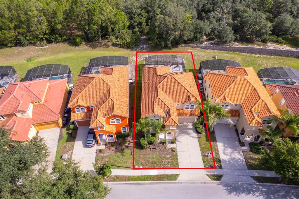 An aerial view shows a two-story house with a tile roof and a screened pool — 406 ORANGE COSMOS BOULEVARD, DAVENPORT, FL