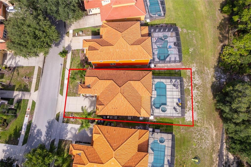 An aerial view shows a house with a tiled roof and a screened-in pool — 406 ORANGE COSMOS BOULEVARD, DAVENPORT, FL