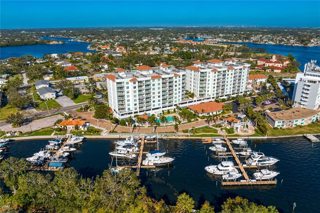 An aerial view shows a multi-story apartment complex with a private marina and swimming pool — 1325 SNELL ISLE BOULEVARD NE UNIT 711, ST PETERSBURG, FL