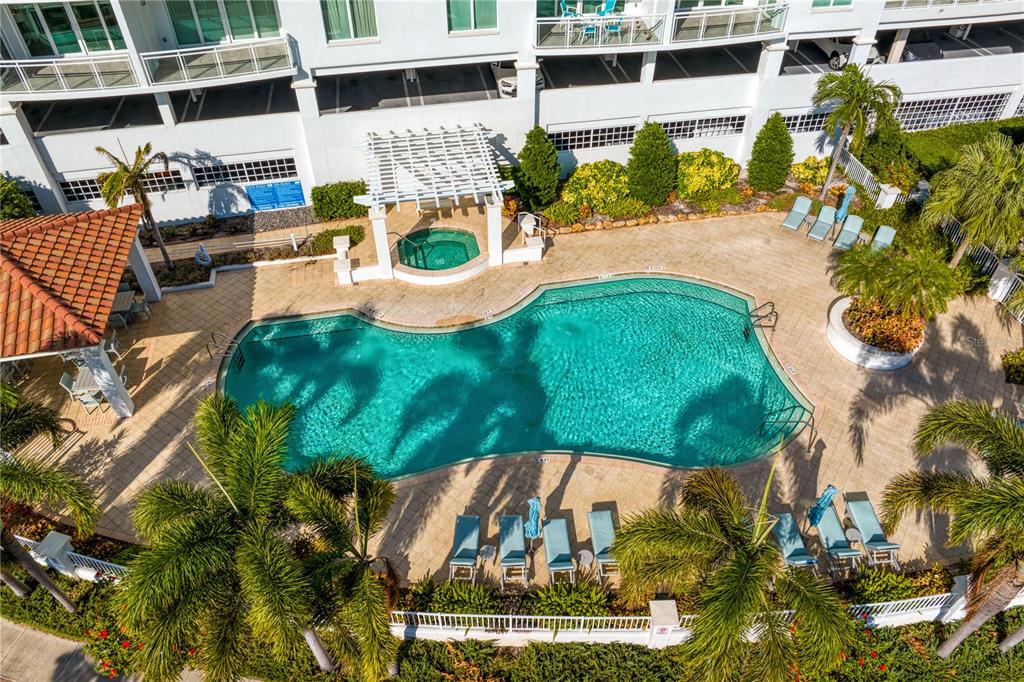 An aerial view of a swimming pool, hot tub, and lounge area at a building — 1325 SNELL ISLE BOULEVARD NE UNIT 711, ST PETERSBURG, FL