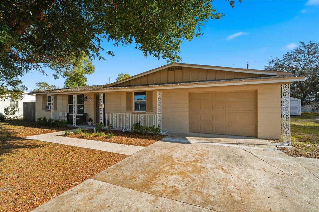 A single-story house with a tan exterior, a one-car garage, and a front porch — 2455 KIMBERLY DRIVE, DELTONA, FL