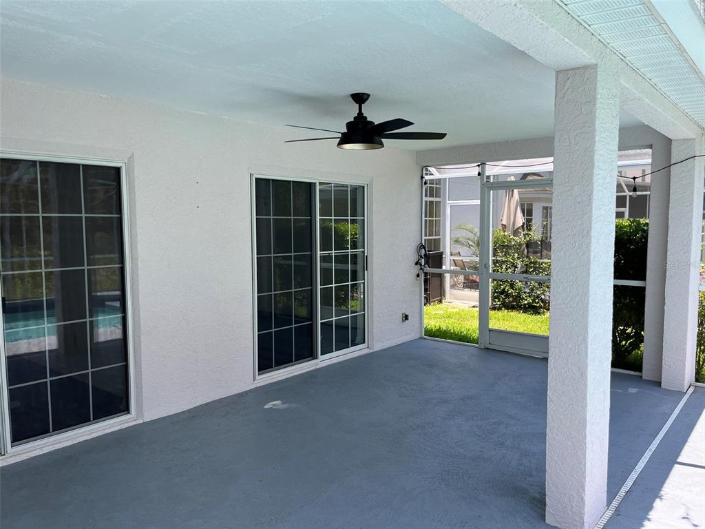 A covered patio with a ceiling fan, gray flooring, and sliding glass doors — 9411 WILLOW COVE COURT, TAMPA, FL