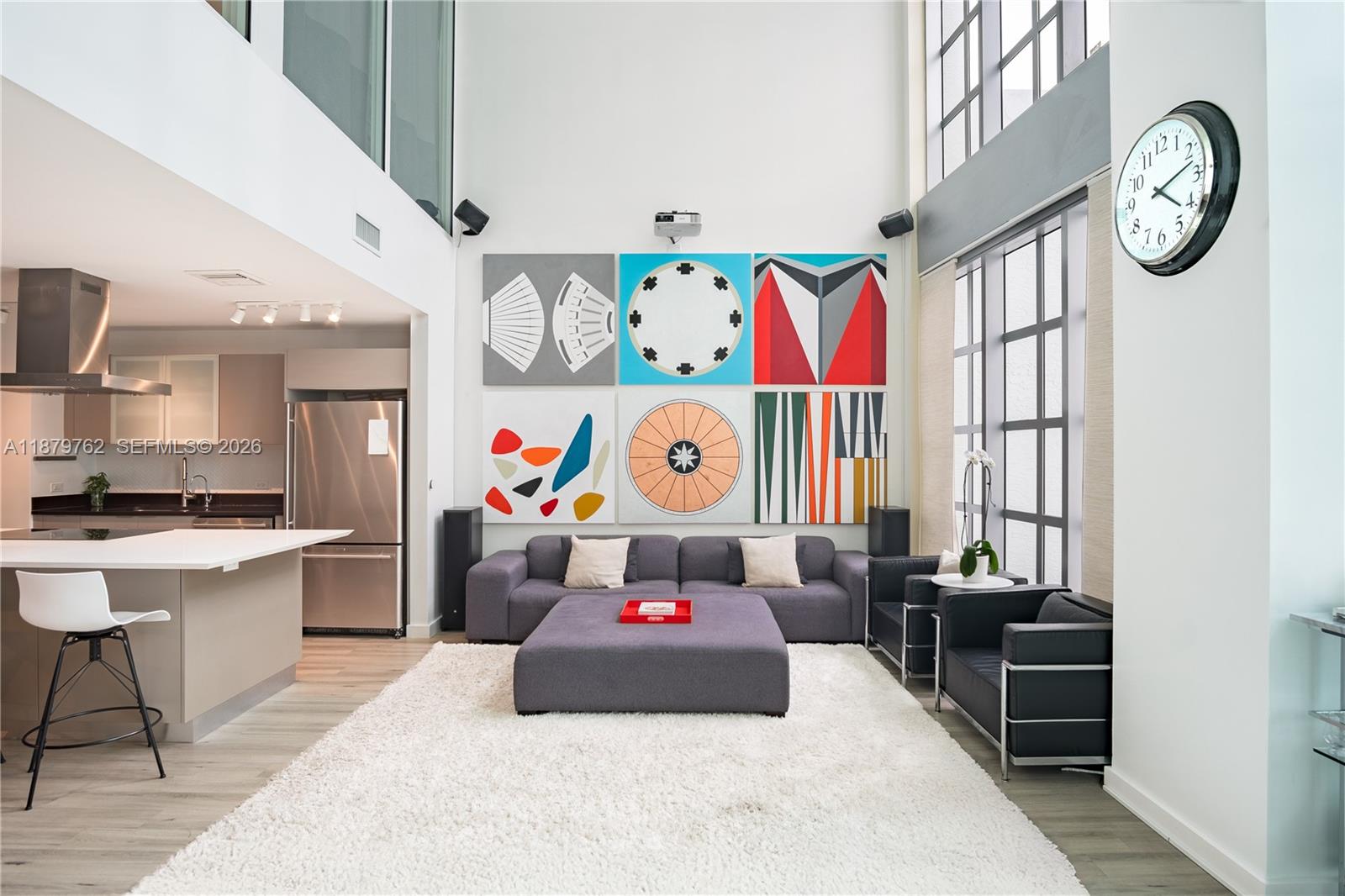 A modern living room with high ceilings, large windows, and a six-panel geometric wall art — 3301 NE 1st Ave # M0501, Miami FL 33137, MIAMI, FL
