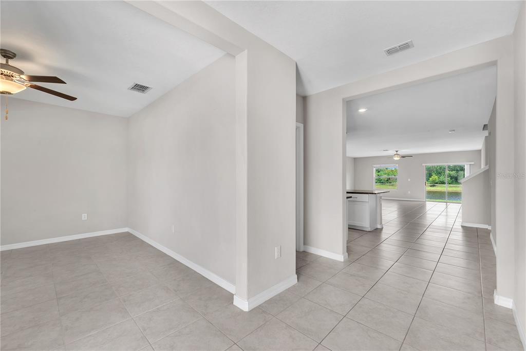 A tiled dining area leads into an open-concept kitchen and living space with water views — 1846 SILVER STAR PLACE, RUSKIN, FL