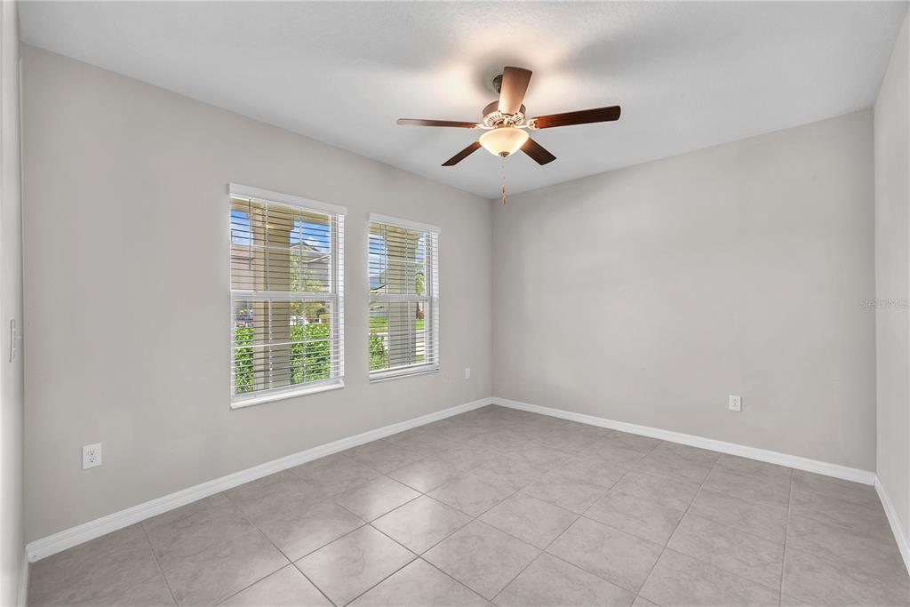An empty room with light gray walls, tile flooring, two windows, and a ceiling fan — 1846 SILVER STAR PLACE, RUSKIN, FL