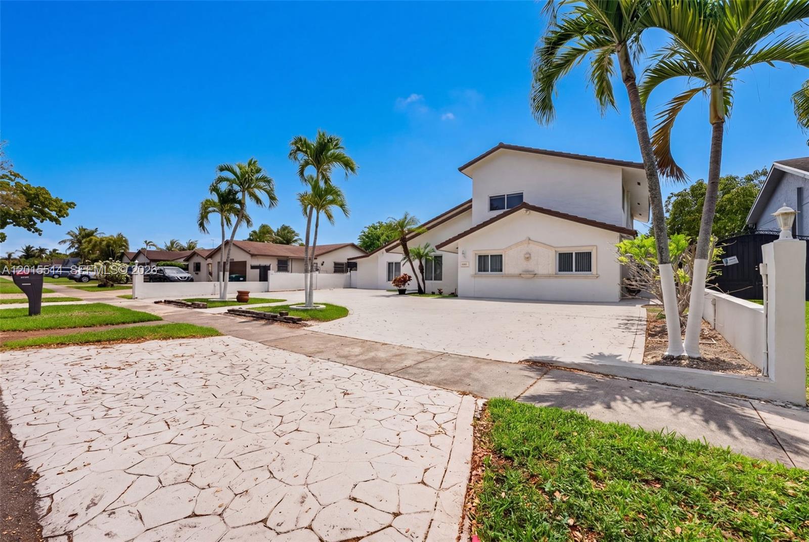 A two-story white house features a large paved driveway and several palm trees — 10934 SW 137th Ct, Miami FL 33186, MIAMI, FL