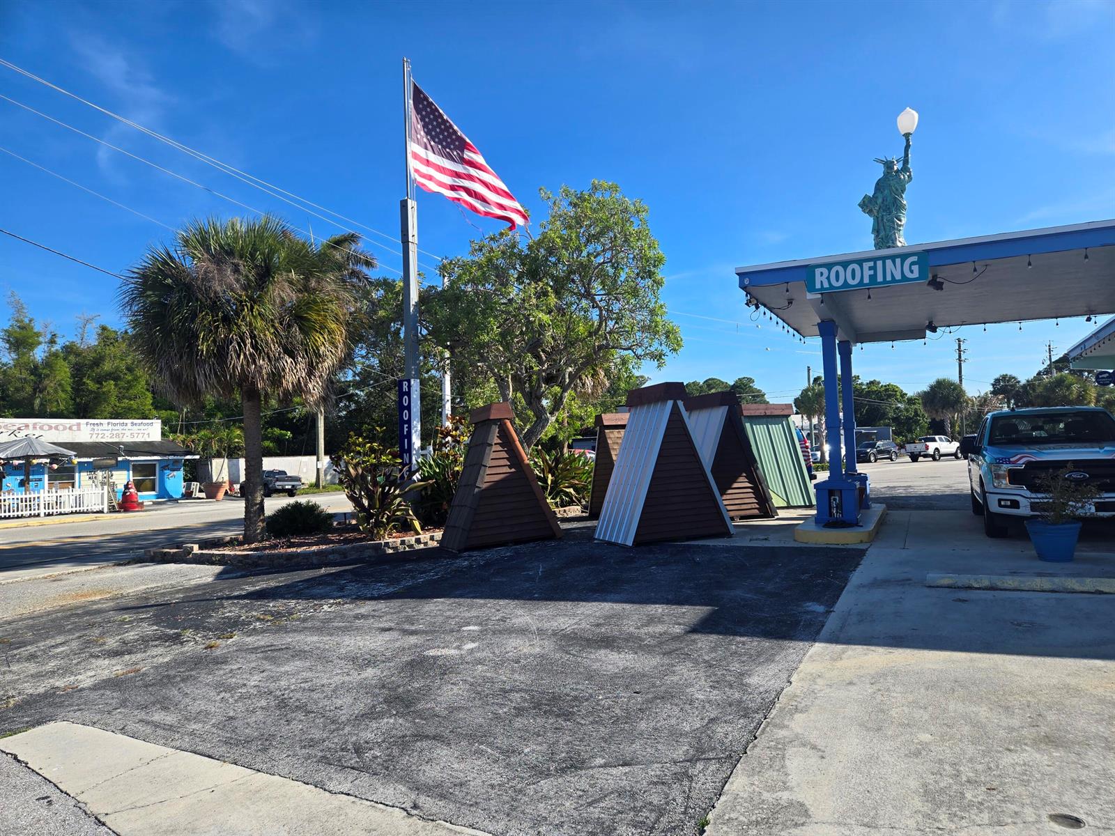 An outdoor view shows a roofing business with a Statue of Liberty replica on top — 4149 SE Salerno Road # A, Stuart FL 34997, STUART, FL
