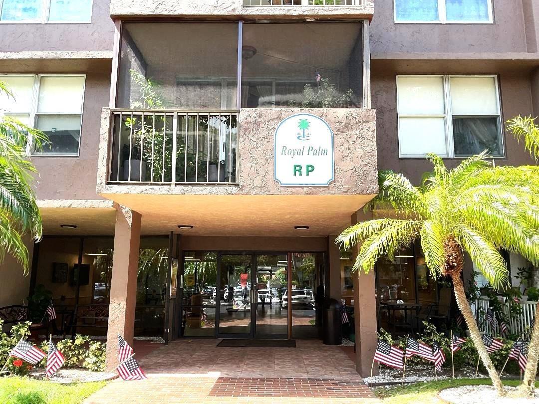 The exterior of a multi-story building features a screened balcony and a ground-level entrance — 777 S Federal Highway, Pompano Beach FL 33062, POMPANO BEACH, FL