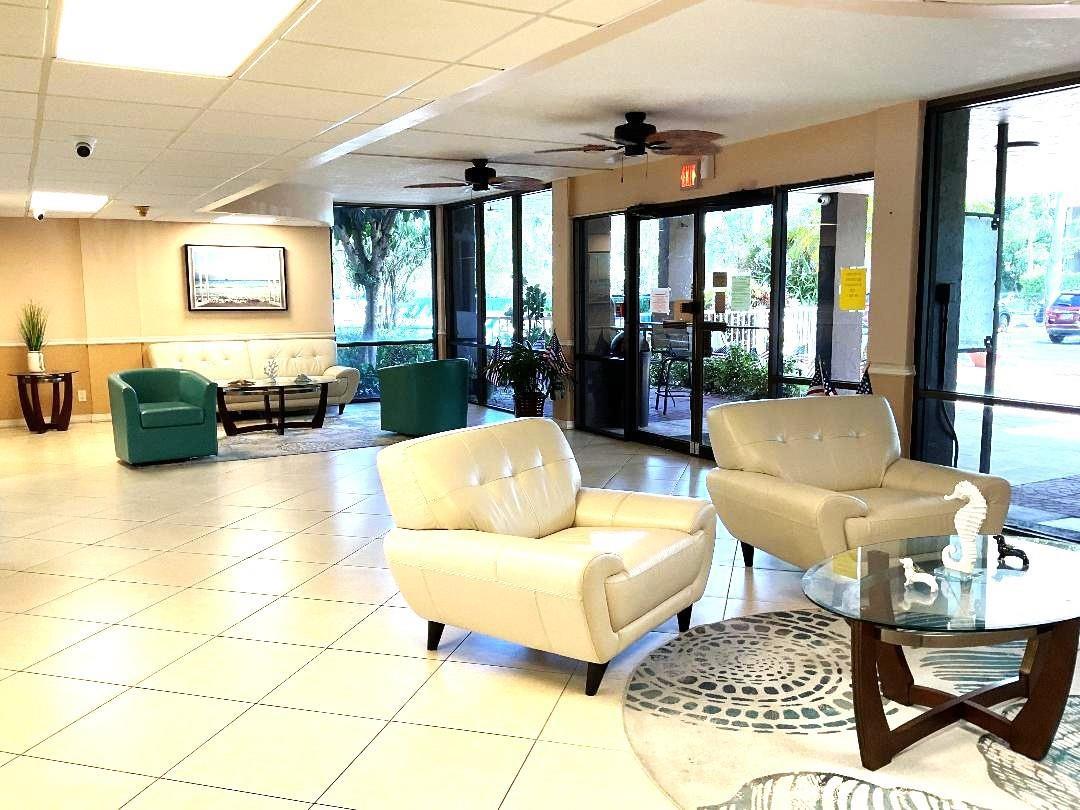 A bright lobby features tiled floors, several armchairs, glass-topped tables, and large windows — 777 S Federal Highway, Pompano Beach FL 33062, POMPANO BEACH, FL