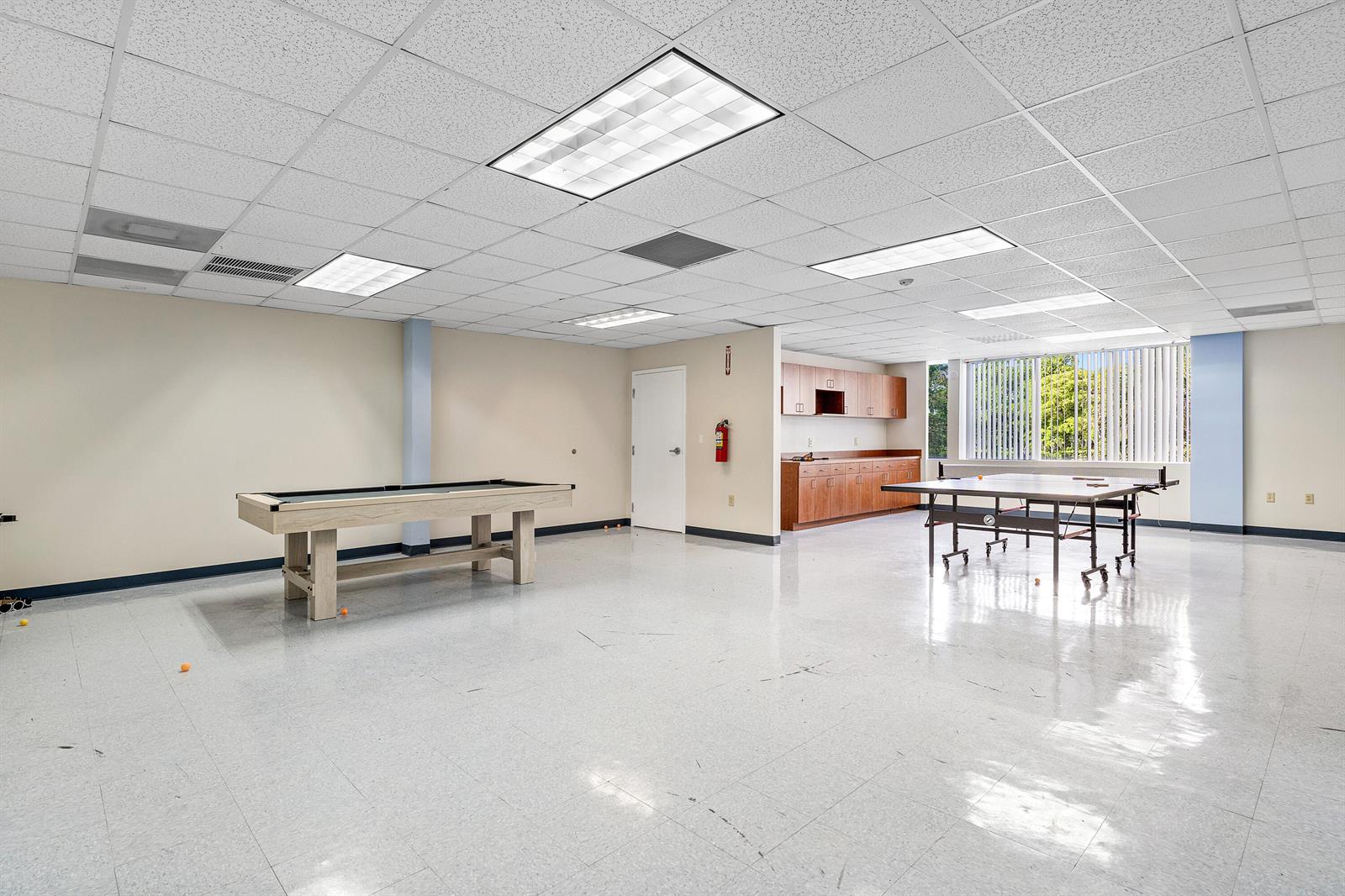 A recreation room features a pool table, a ping pong table, and wood cabinetry — 555 SW 12th Avenue, Pompano Beach FL 33069, POMPANO BEACH, FL