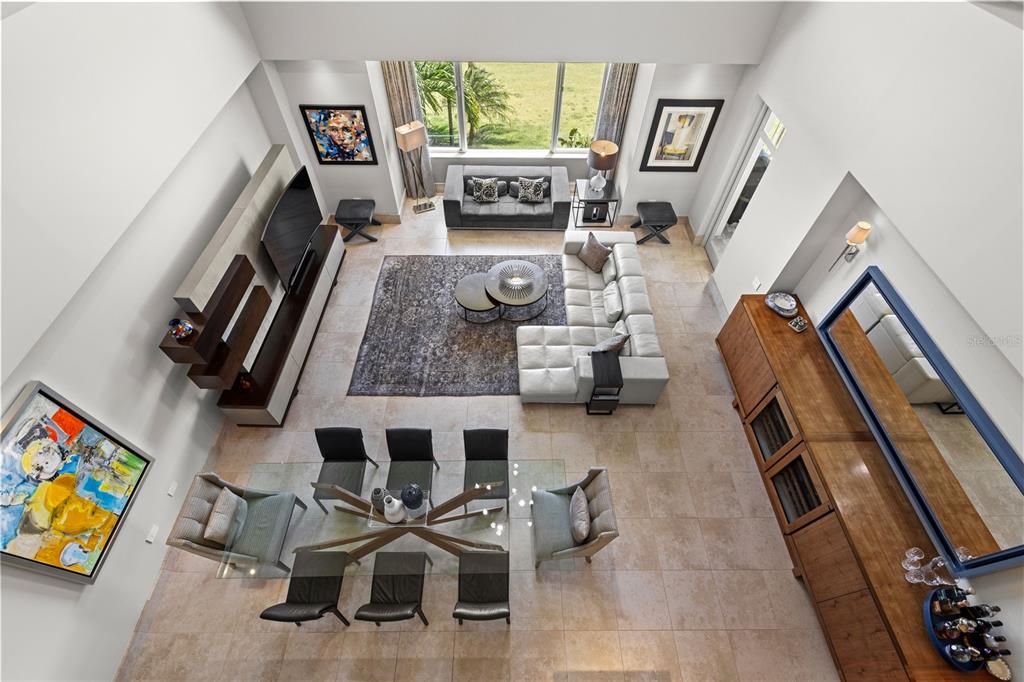 An elevated view of a modern living and dining area with tile floors and high ceilings — 500 PLANTATION DRIVE UNIT 3-202, DORADO, PR