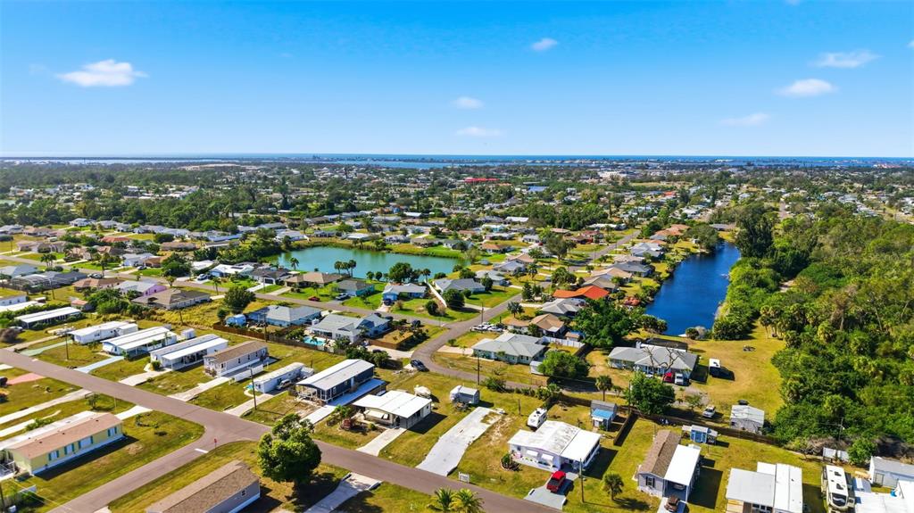 An aerial view shows a residential neighborhood with mobile homes, two ponds, and surrounding trees — 1372 IBIS DRIVE, ENGLEWOOD, FL