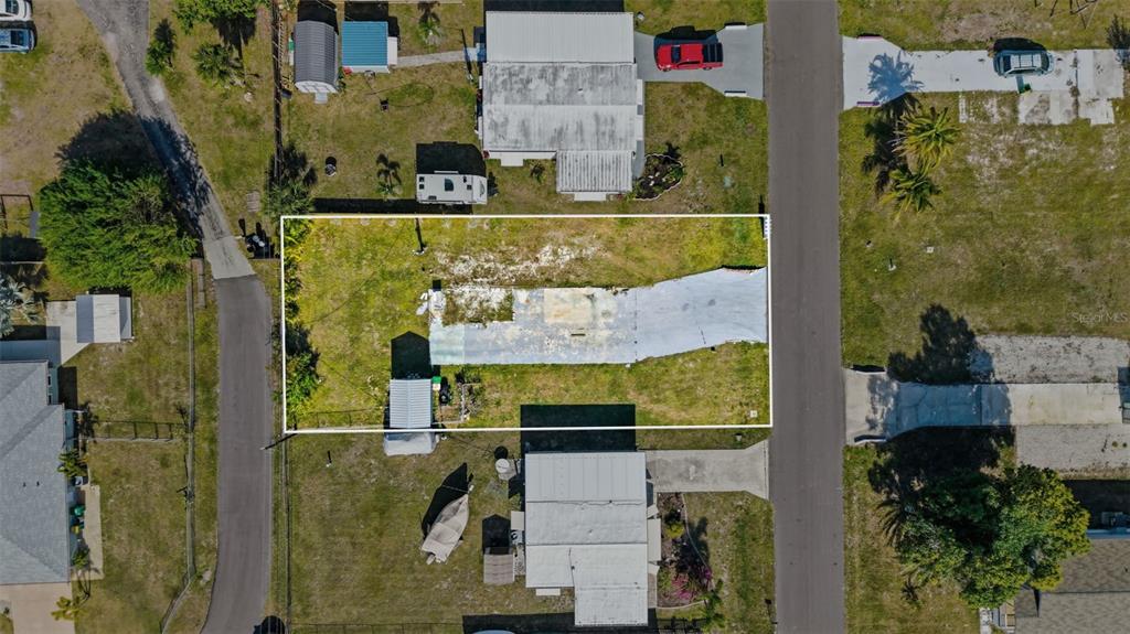 An aerial view shows a rectangular residential lot containing a weathered concrete slab and shed — 1372 IBIS DRIVE, ENGLEWOOD, FL