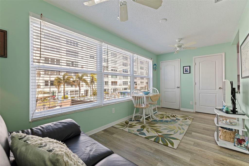A swimming pool with a mural on the wall sits beside a multi-story apartment building — 2960 59TH STREET S UNIT 210, GULFPORT, FL