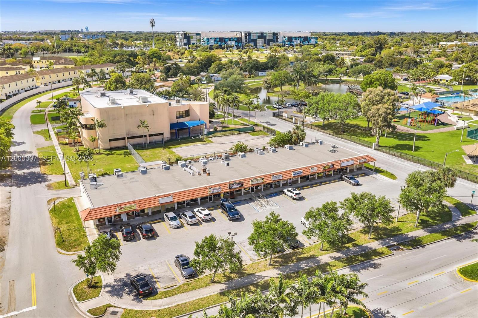 An aerial view shows a commercial strip mall with a parking lot and surrounding greenery — 4200 NW 12th St, Lauderhill FL 33313, LAUDERHILL, FL