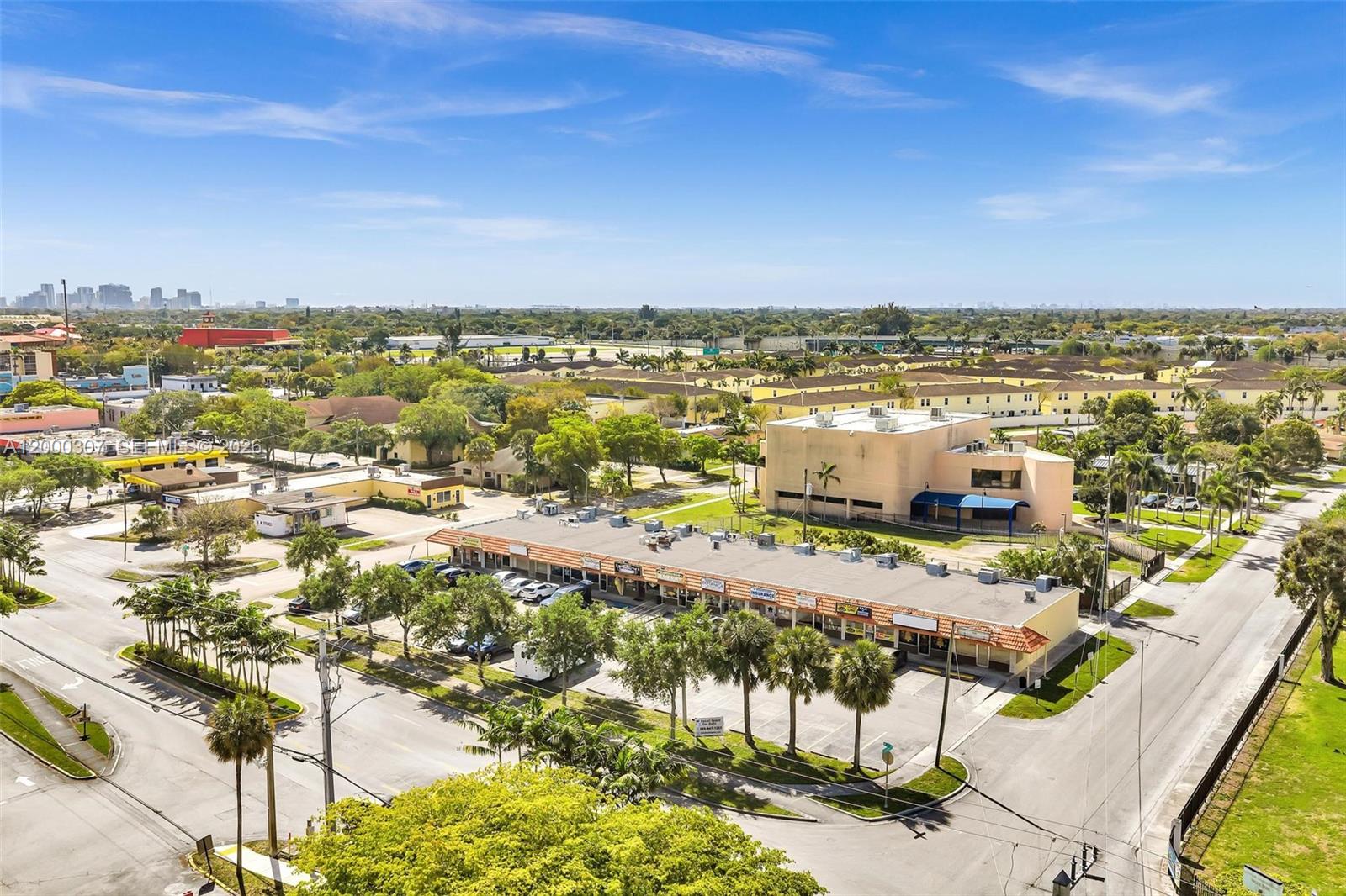 An aerial view shows a commercial strip mall with a parking lot and surrounding buildings — 4200 NW 12th St, Lauderhill FL 33313, LAUDERHILL, FL