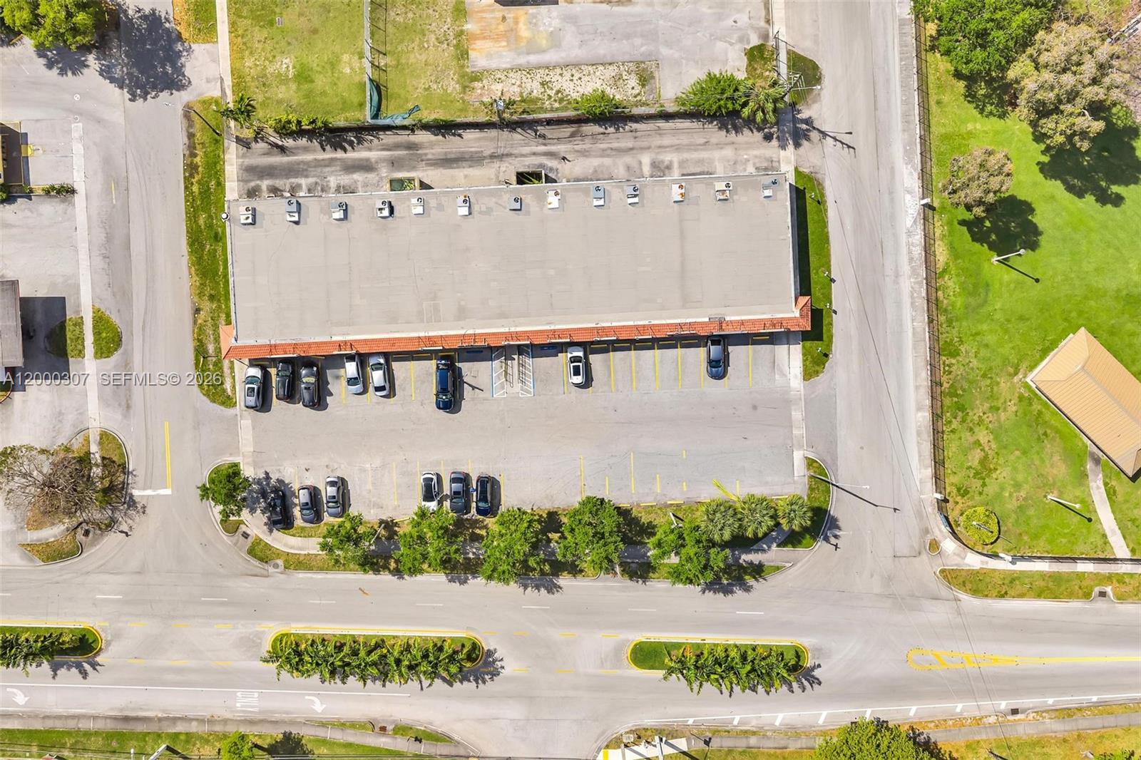 An aerial view shows a commercial building with a parking lot and surrounding landscaping — 4200 NW 12th St, Lauderhill FL 33313, LAUDERHILL, FL