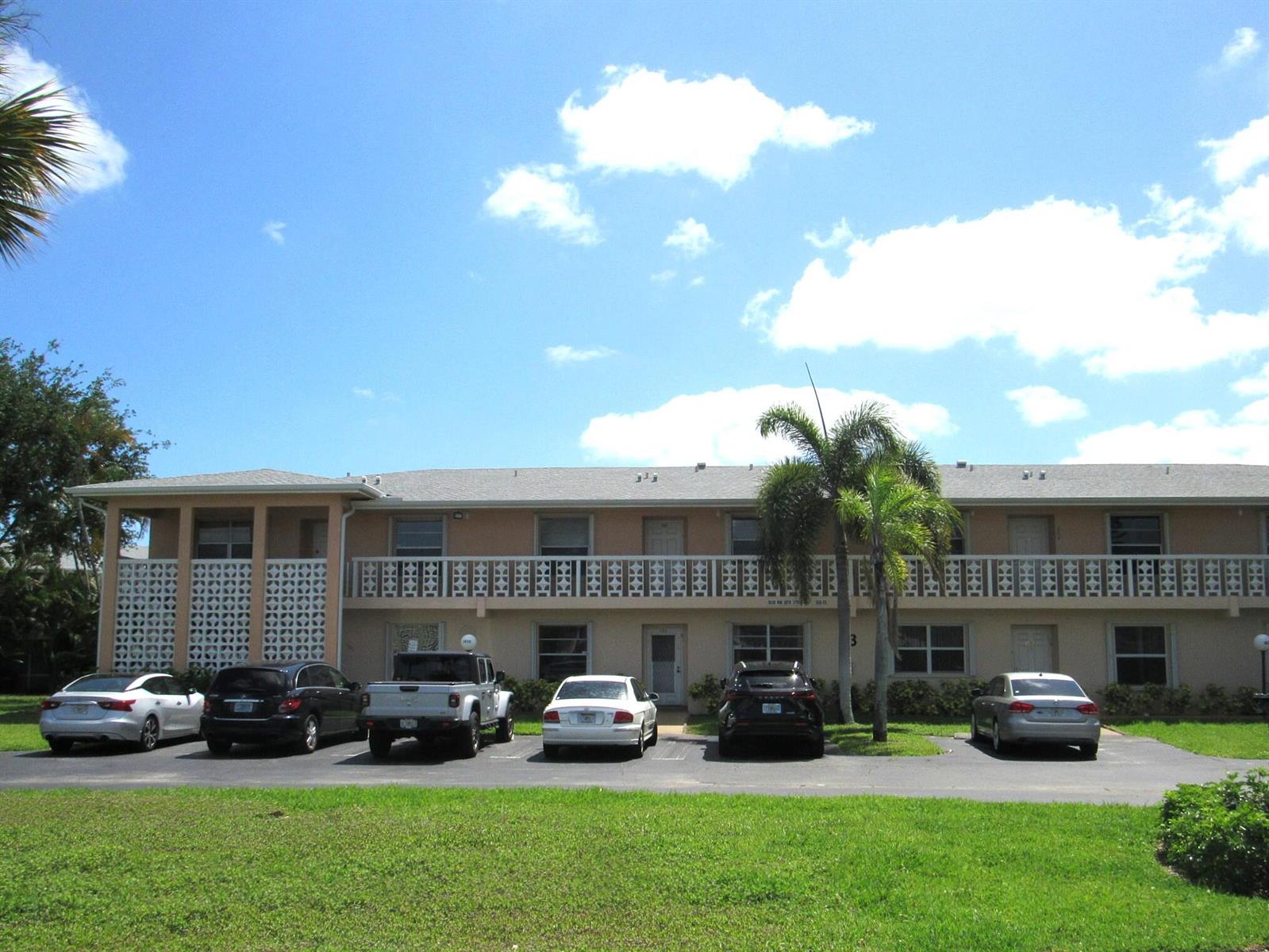 A two-story apartment building with a parking lot and palm trees in front — 1830 NW 18th Street # 201, Delray Beach FL 33445, DELRAY BEACH, FL