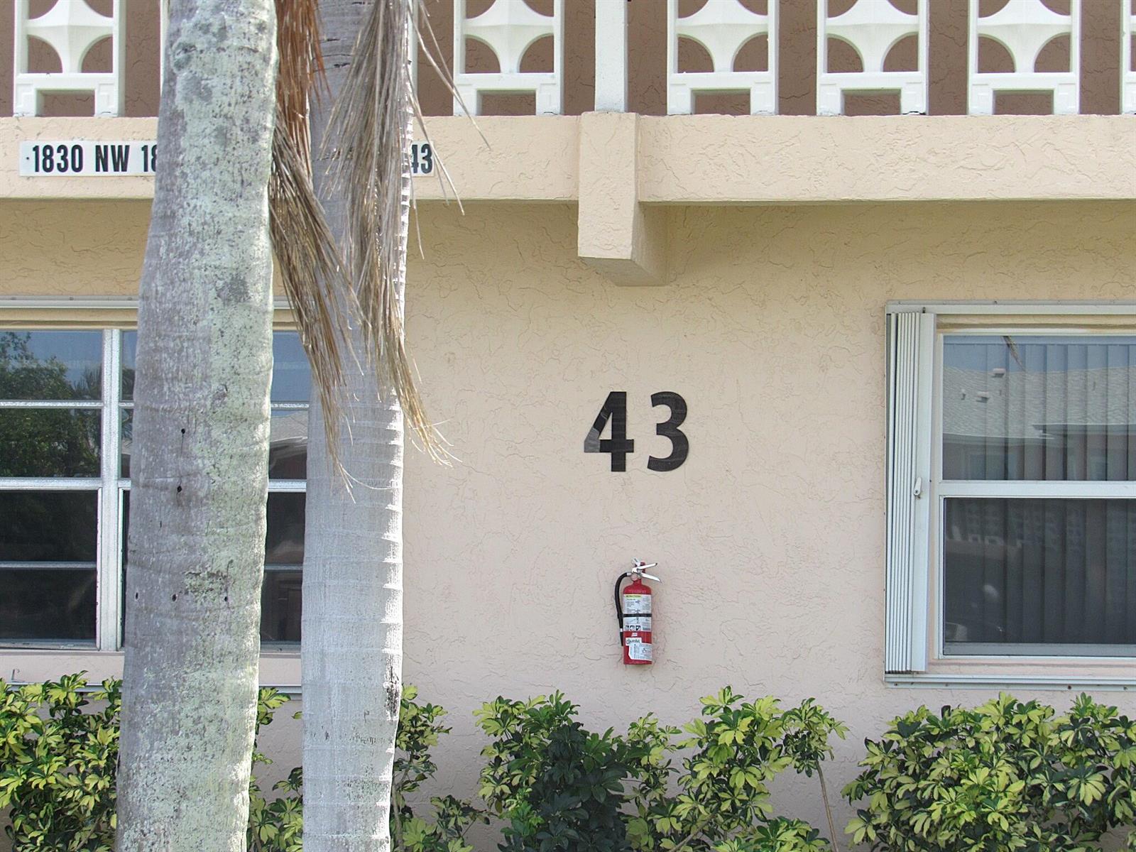 The exterior wall of a building features the number 43 and a mounted fire extinguisher — 1830 NW 18th Street # 201, Delray Beach FL 33445, DELRAY BEACH, FL