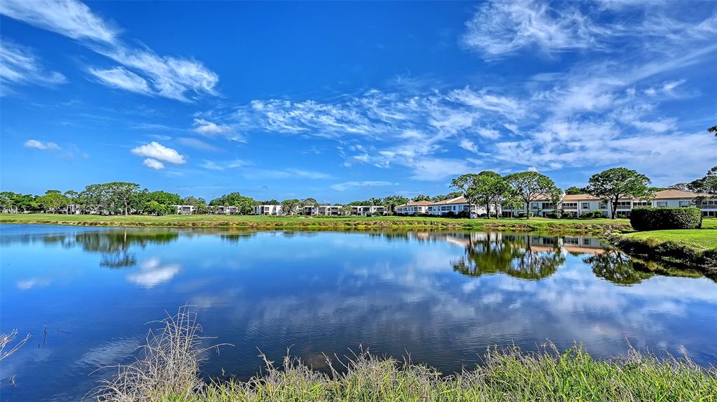 An outdoor swimming pool with a white fence and a small utility building nearby — 5207 WILLOW LINKS UNIT 34, SARASOTA, FL