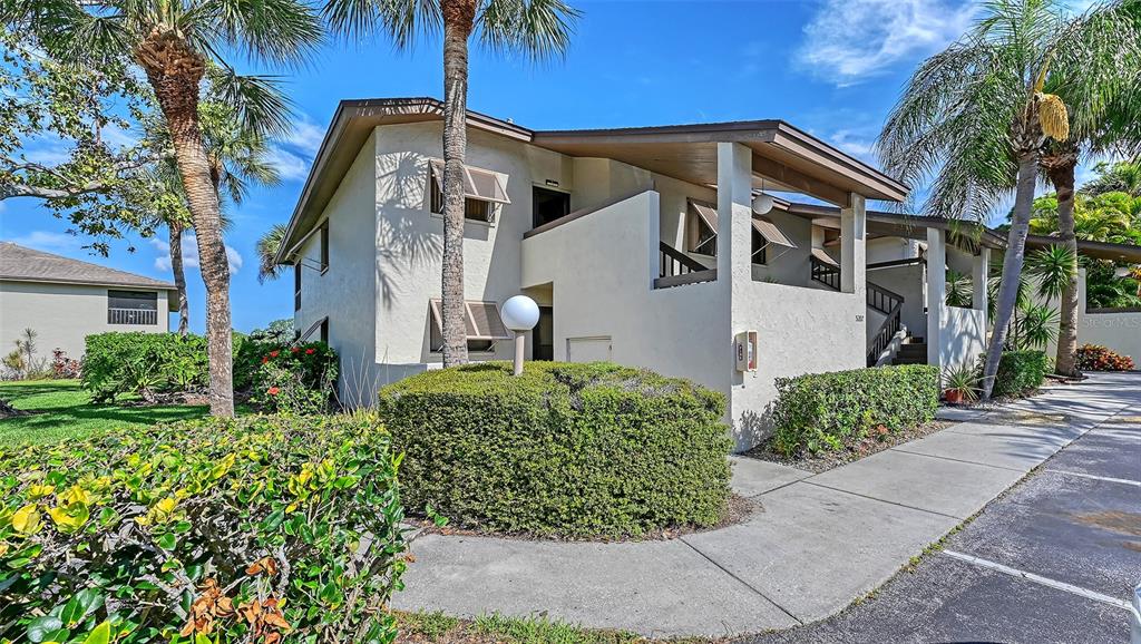 A living room features a wicker dresser, a sofa, a recliner, and a balcony view — 5207 WILLOW LINKS UNIT 34, SARASOTA, FL