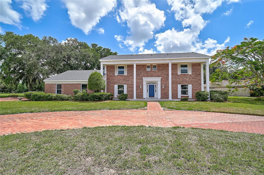 A two-story brick house with a blue front door and a curved brick driveway — 3215 PINE VALLEY DRIVE, SARASOTA, FL