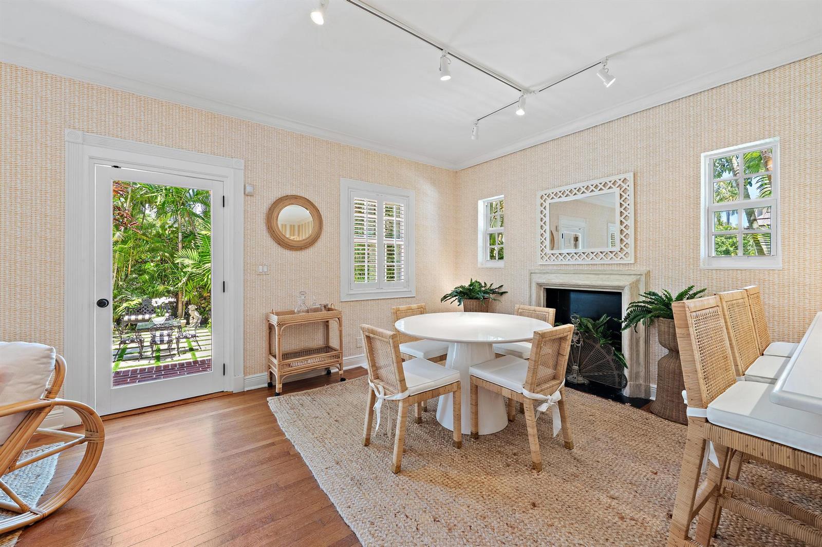 A dining room features a round table, rattan chairs, a fireplace, and a glass door — 151 S County Road, Palm Beach FL 33480, PALM BEACH, FL