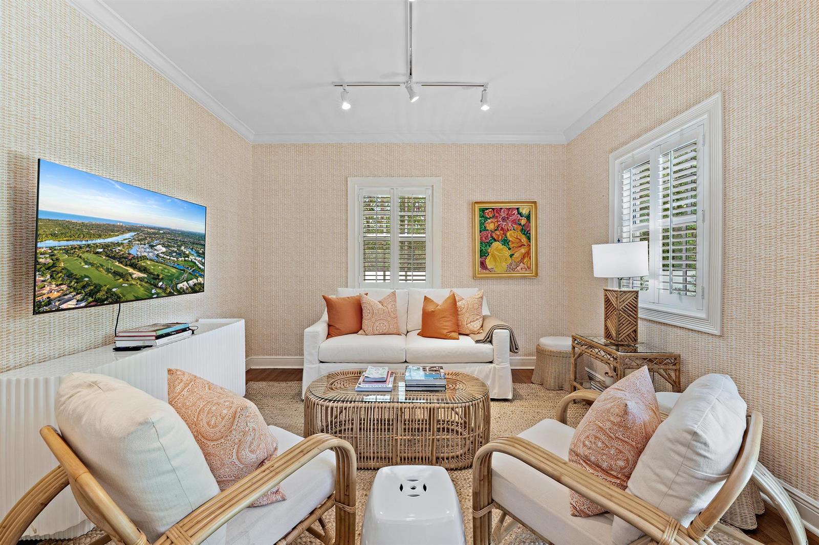 A living room features a white sofa, two rattan armchairs, a television, and textured wallpaper — 151 S County Road, Palm Beach FL 33480, PALM BEACH, FL