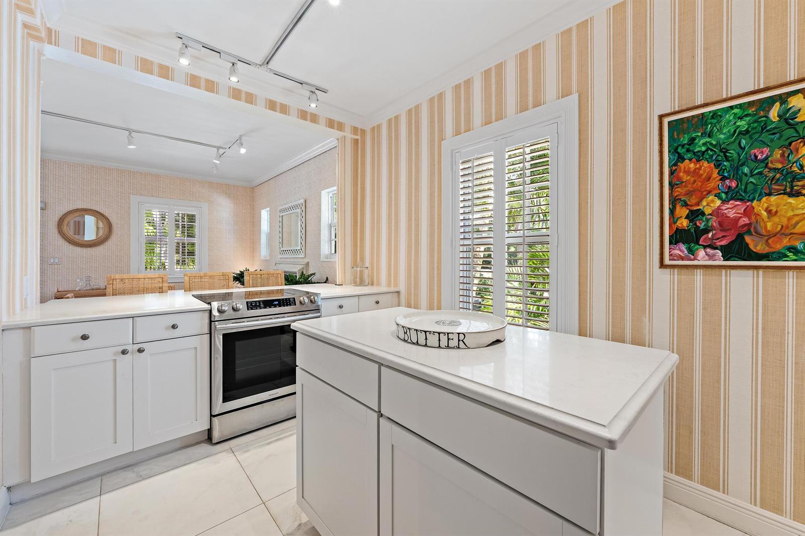 A kitchen features white cabinetry, a stainless steel stove, and striped wallpaper — 151 S County Road, Palm Beach FL 33480, PALM BEACH, FL