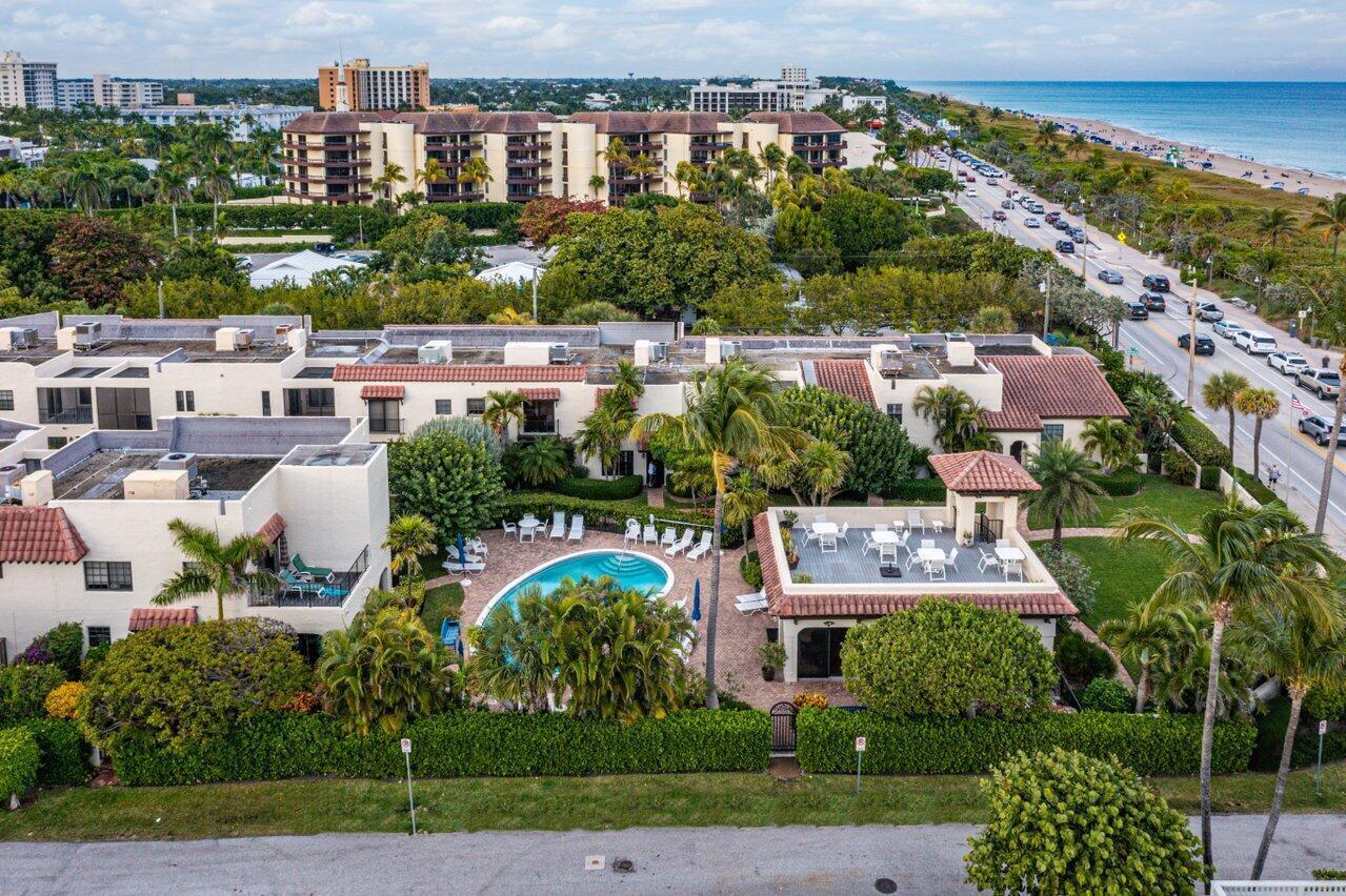 An aerial view of a multi-story apartment complex featuring a swimming pool and rooftop patio — 200 S Ocean Boulevard # 105, Delray Beach FL 33483, DELRAY BEACH, FL
