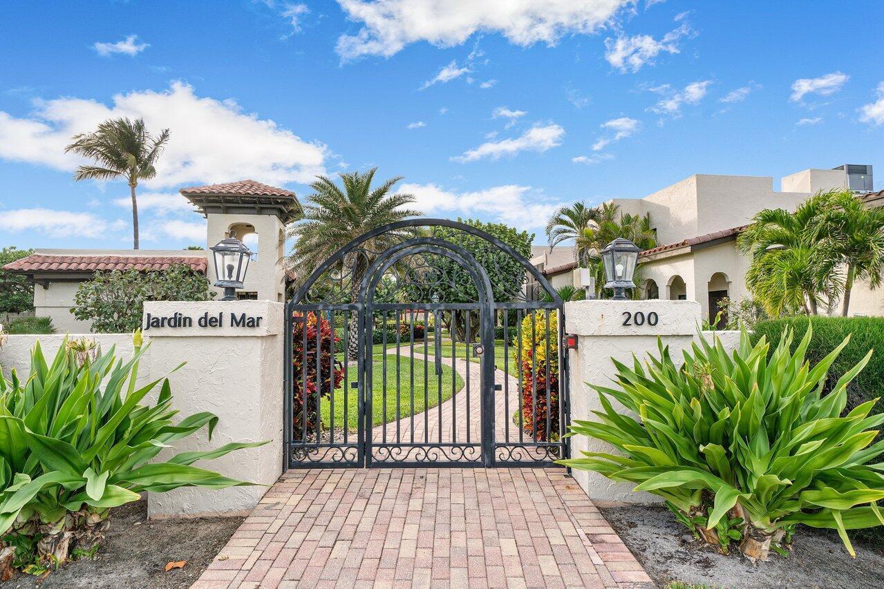 A brick walkway leads to a black metal gate at the entrance of a property — 200 S Ocean Boulevard # 105, Delray Beach FL 33483, DELRAY BEACH, FL