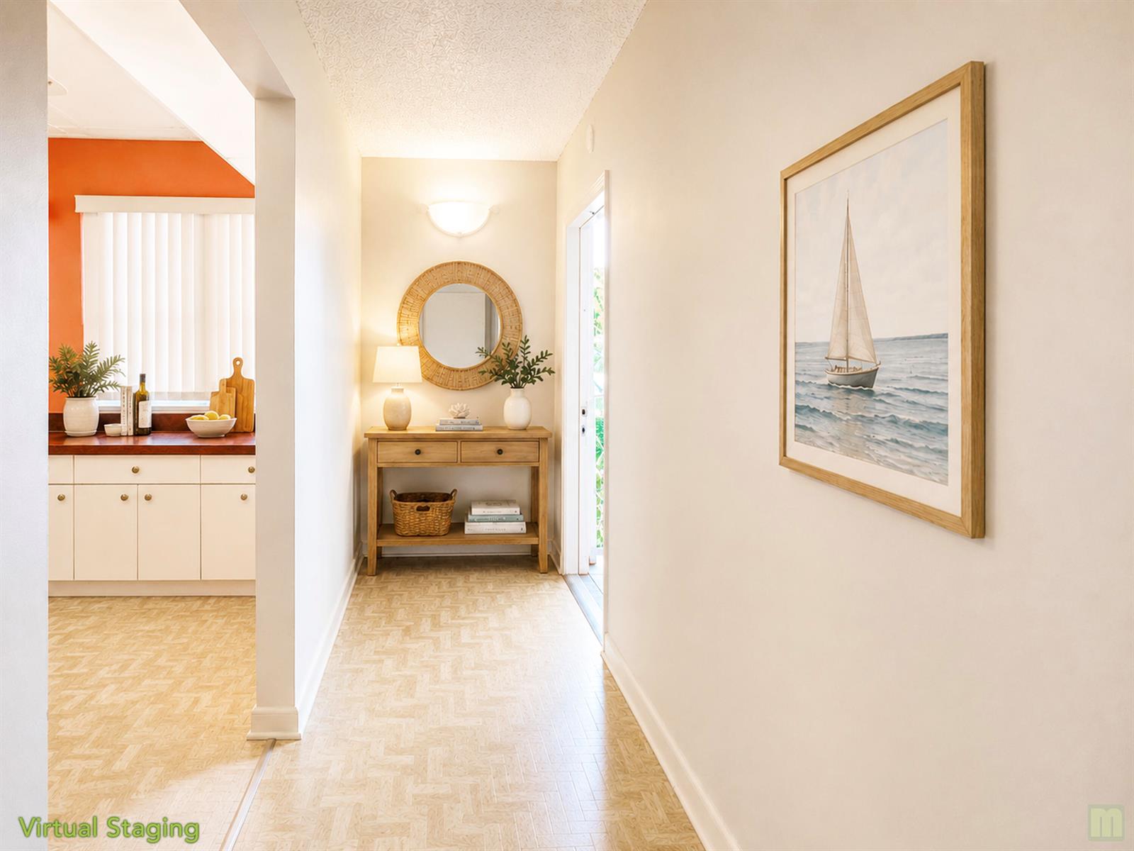 A hallway with a console table, round mirror, and sailboat artwork leads to a kitchen — 1901 Bermuda Circle # M2, Coconut Creek FL 33066, COCONUT CREEK, FL